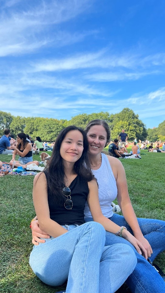 Fun photo of Dr. Chloe Lee and her partner sitting in the grass.