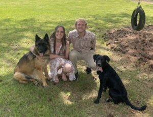 Dr. Christian Casteel; fun photo in the park with his spouse and two dogs.
