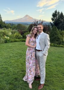 Dr. Dayna Carlson; fun photo with her spouse posing in front of a mountain.