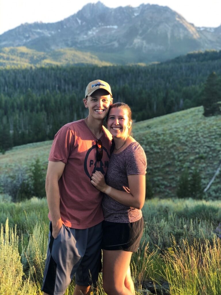 A photograph of Benjamin Showalter and his significant other Mallory standing in front of a mountainous landscape.