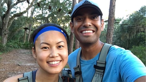 A selfie photo of Omar Syed (right) and his significant other Emily (left) hiking on a trail and ropes course in the background.