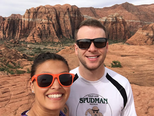 Rok Holmes and his wife Sydney Holmes taking a selfie in front of red rocks type of landscape.